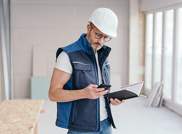 Trabajador de la obra revisando su dispositivo
