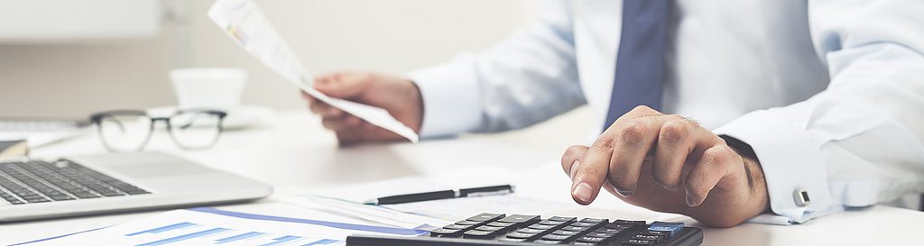 Ein Mann bearbeitet unterlagen und rechnet mit einem Taschenrechner. Besser fakturieren mit GPS-Ortung von geoCapture