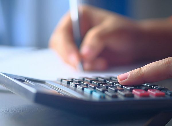 Primer plano de una mano tecleando en una calculadora